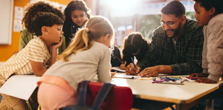 Assistant at a table with engaged young children